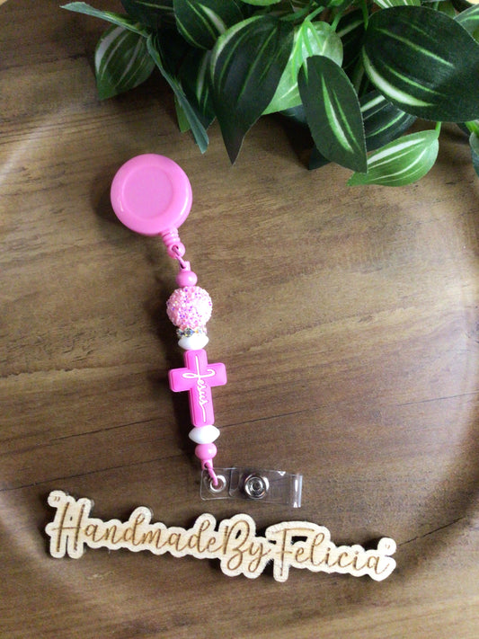 Pink and white cross badge reel