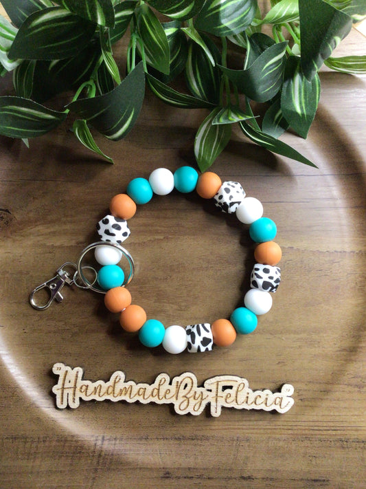 Rustic orange, teal, white an cow print wristlet