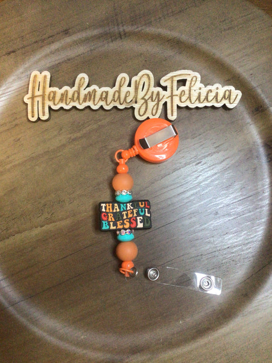 Thankful orange badge reel