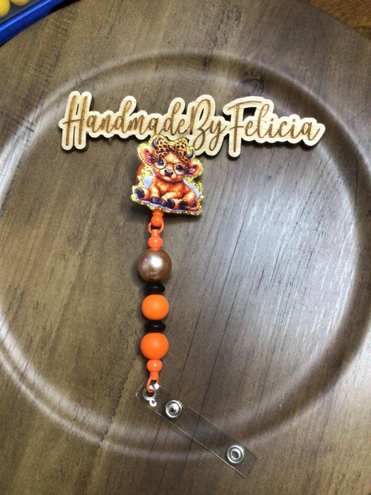 Cow with orange and gold badge reel