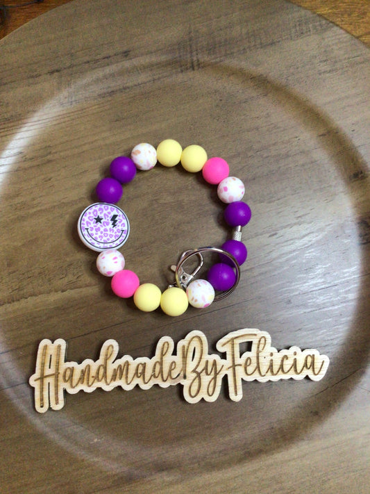 Purple smiley face wristlet