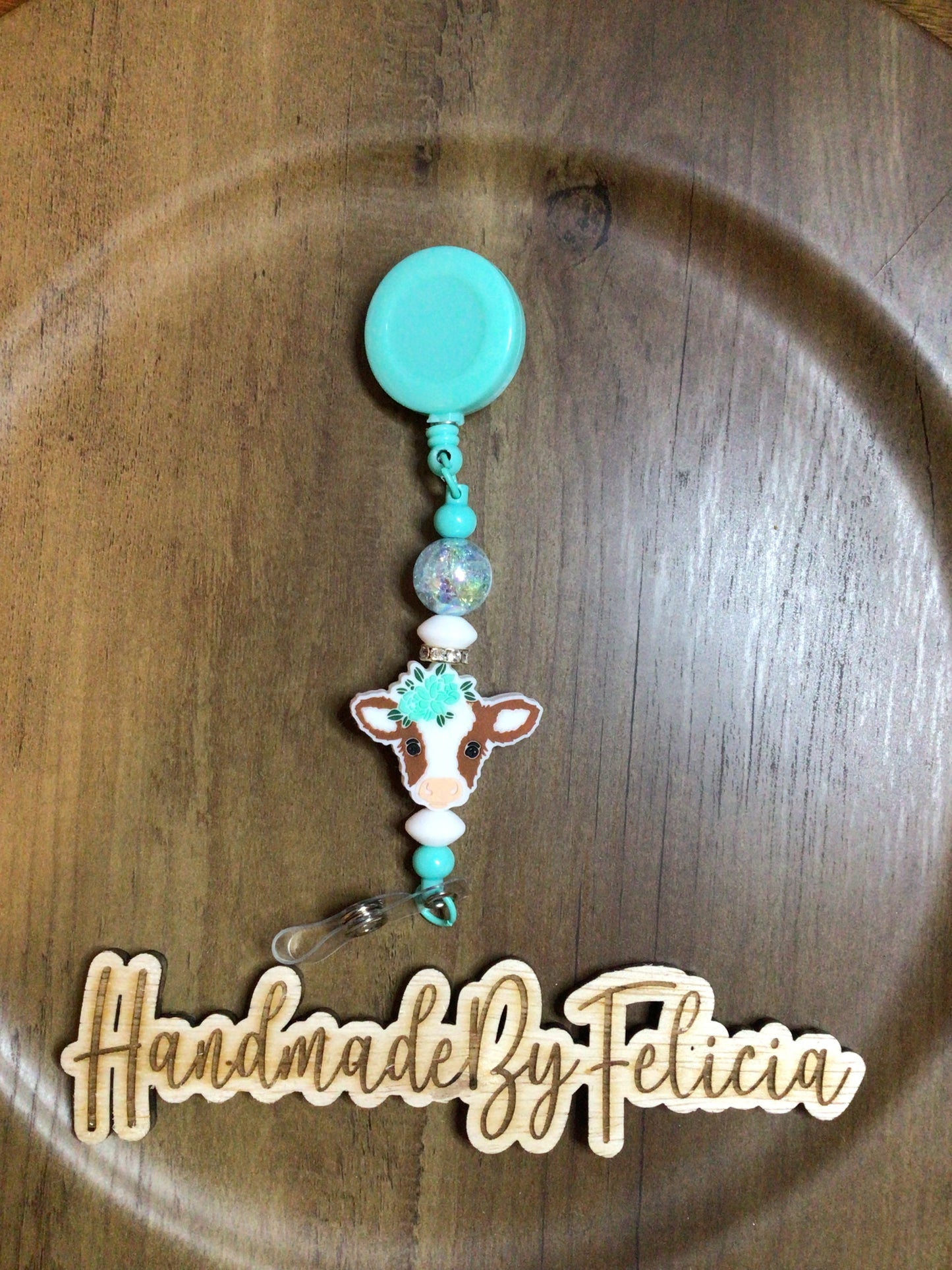 Brown white cow badge reel in teal